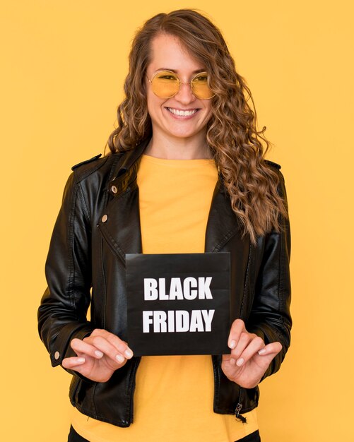 Mujer con gafas y sosteniendo la etiqueta del viernes negro
