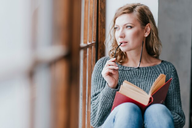 Mujer con gafas sosteniendo el libro