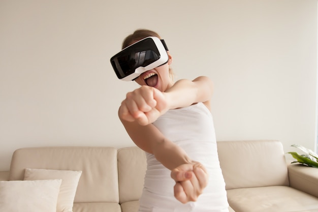 Mujer en gafas VR disfrutando juegos 3d en casa