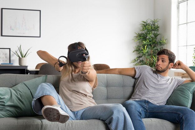 Mujer con gafas vr en sofá tiro medio