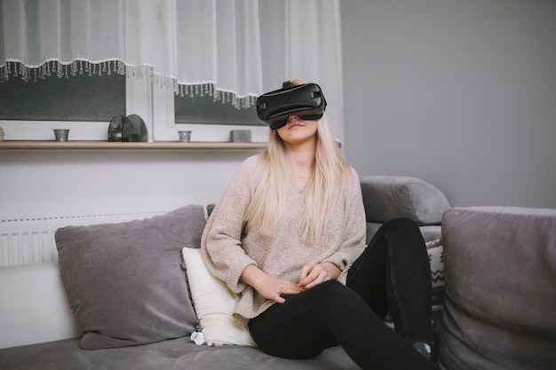 Mujer en gafas VR en el sofá