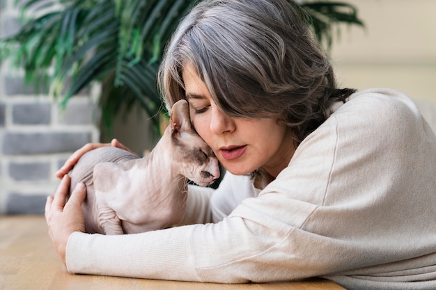 Foto gratuita mujer y gato siendo afectuoso plano medio