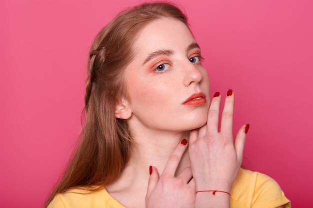 Mujer gentil con maquillaje brillante, cabello liso con tono rojo