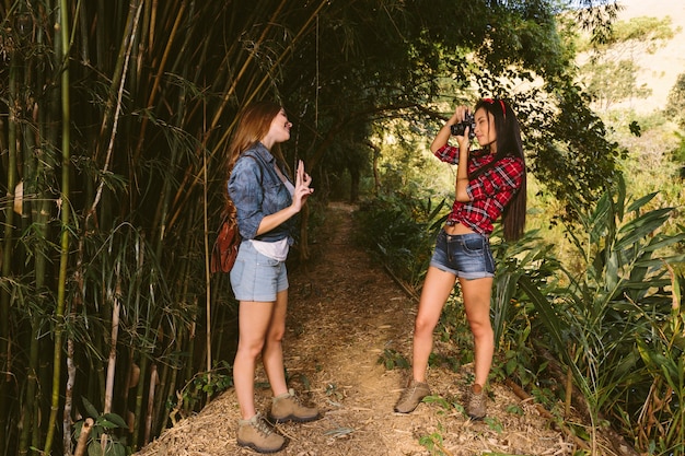 Mujer gesticulando mientras su amigo toma una fotografía con la cámara