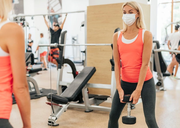 Mujer en el gimnasio entrenando con máscara