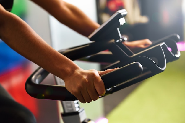 Mujer en un gimnasio haciendo spinning o cyclo indoor con reloj inteligente