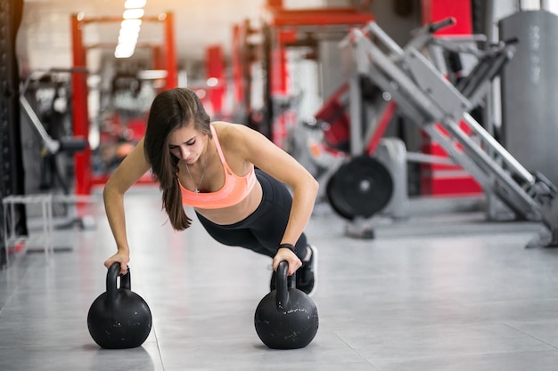 Mujer en el gimnasio con kettlebells