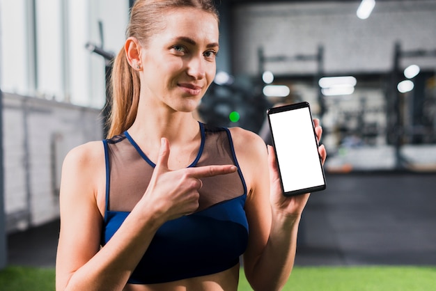 Mujer en gimnasio con plantilla de smartphone