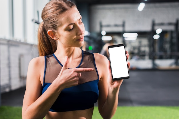 Foto gratuita mujer en gimnasio con plantilla de smartphone