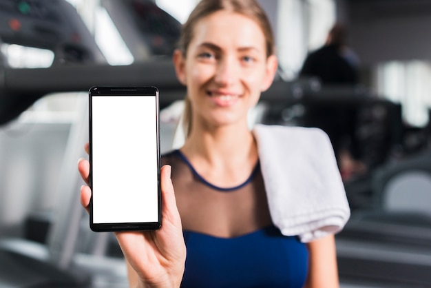 Foto gratuita mujer en gimnasio con plantilla de smartphone