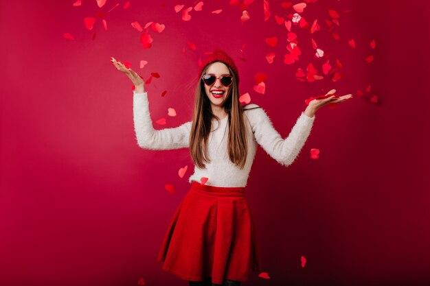 Mujer glamorosa bien formada en gafas de sol bailando en la fiesta