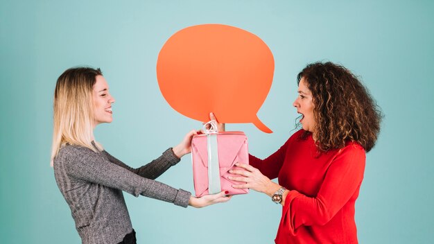 Mujer con globo de discurso que recibe el regalo de la hija