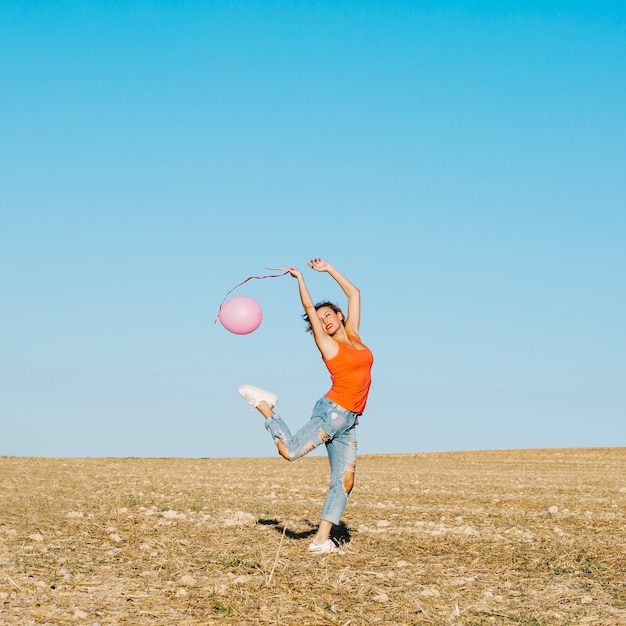 Foto gratuita mujer con globo rosa en la naturaleza