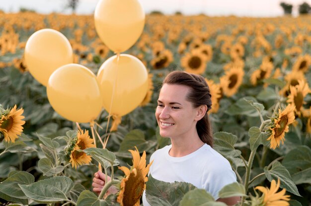 Mujer con globos en campo de girasol