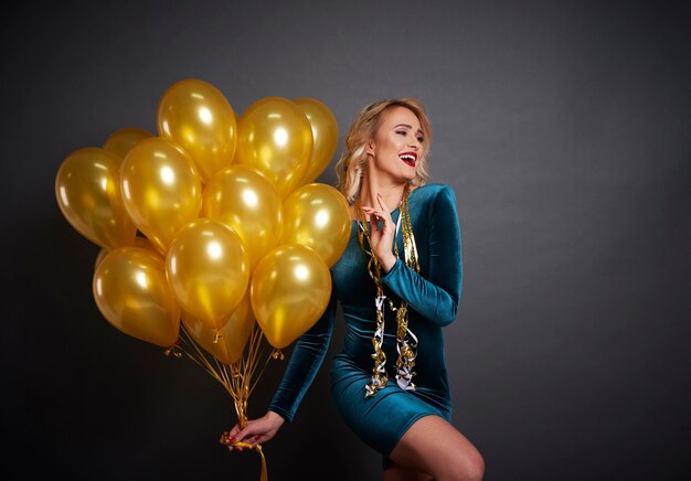 Mujer con globos mirando espacio de copia