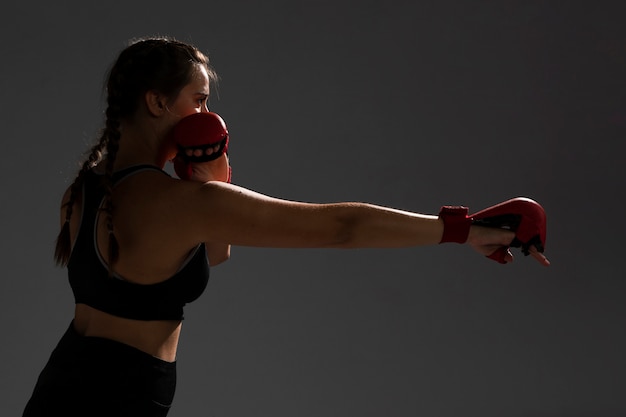 Mujer golpeando con guantes de box