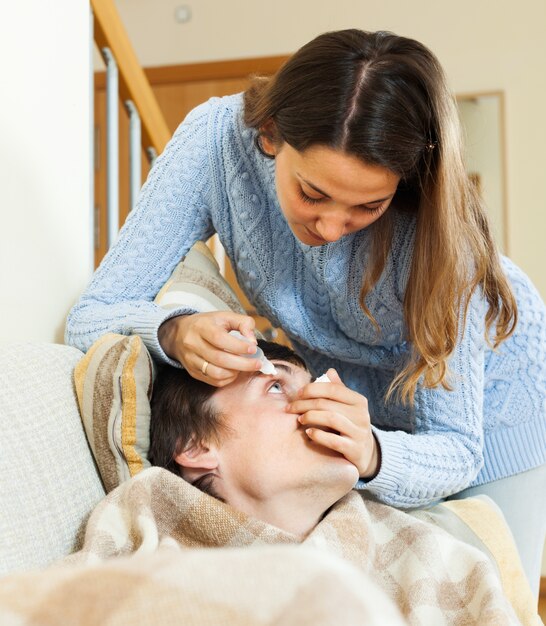 mujer goteando gotas para el hombre