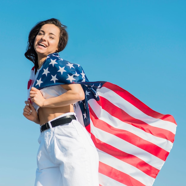 Foto gratuita mujer con gran bandera de estados unidos como capa