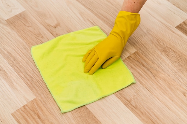 Mujer con guante de goma limpiando el piso