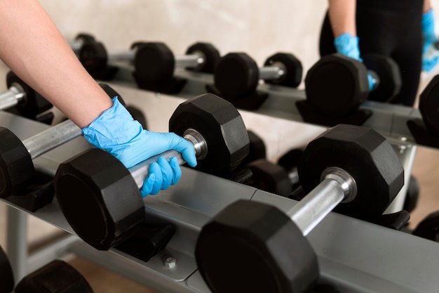 Mujer con guante sosteniendo peso en el gimnasio