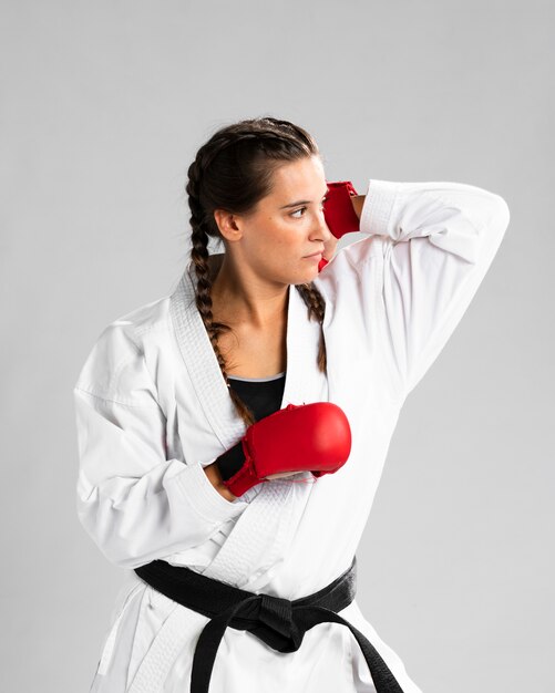 Mujer con guantes de box sobre fondo blanco.