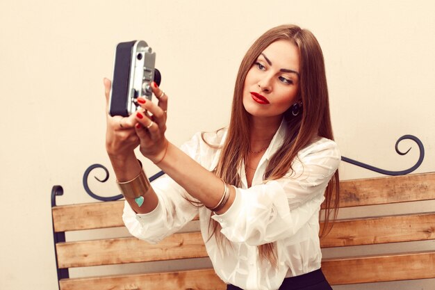 Mujer guapa jugando con su cámara vintage