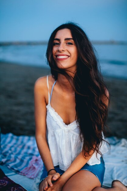 Mujer guapa sentada en la playa