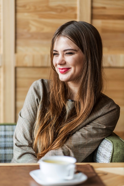 Mujer guapa sonriendo en una cafetería