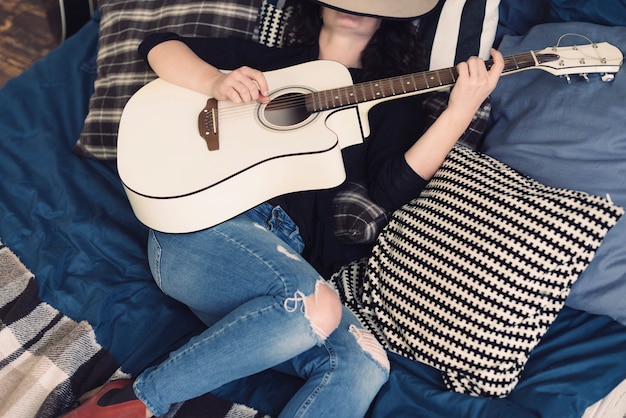 Foto gratuita mujer con guitarra en la cama