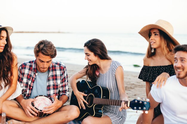 Mujer con guitarra a lado de sus amigos