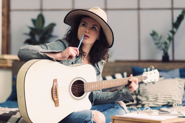 Mujer con guitarra y lápiz