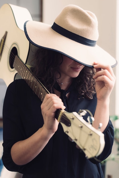 Foto gratuita mujer con guitarra y sombrero