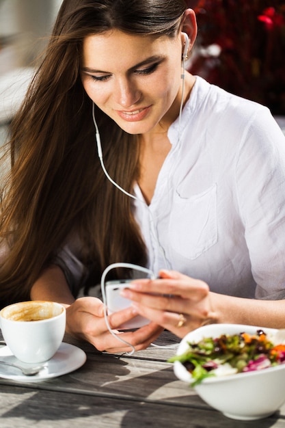 Mujer habla a través de auriculares en el teléfono