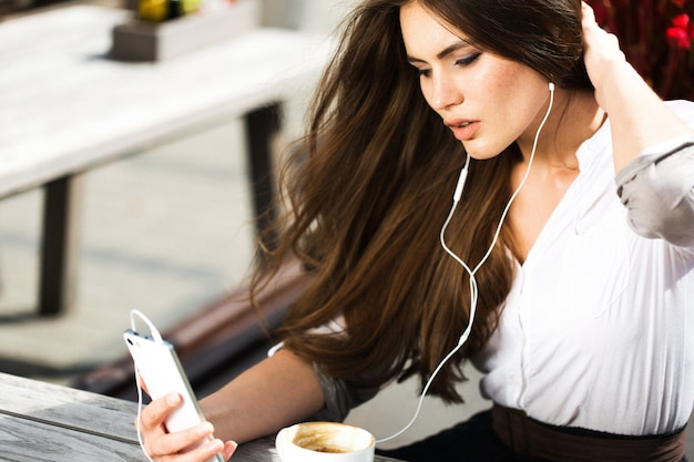 Mujer habla a través de auriculares en el teléfono