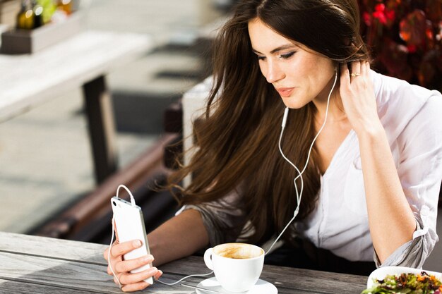 Mujer habla a través de auriculares en el teléfono