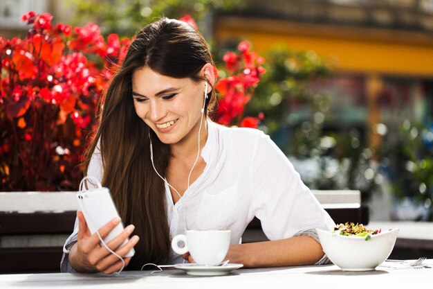 Mujer habla a través de auriculares en el teléfono