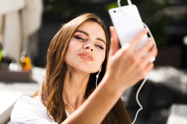 Mujer habla a través de auriculares en el teléfono