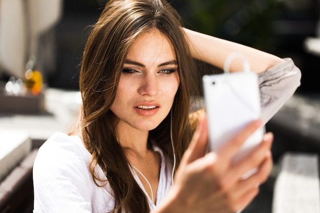 Mujer habla a través de auriculares en el teléfono