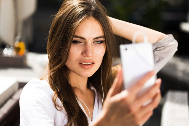 Mujer habla a través de auriculares en el teléfono