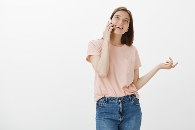 Mujer habladora tonta hablando por teléfono, gesticulando y sonriendo