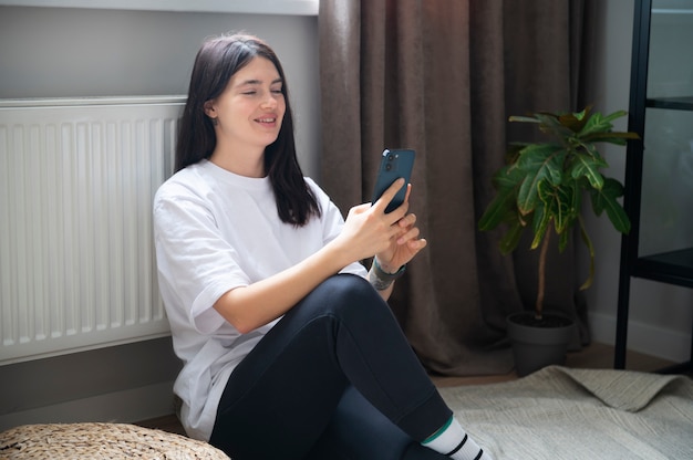 Mujer hablando por su teléfono inteligente en casa durante la cuarentena