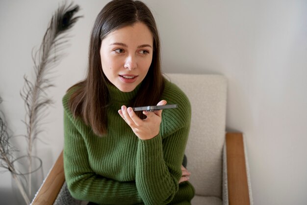 Mujer hablando por su teléfono inteligente con la función de manos libres