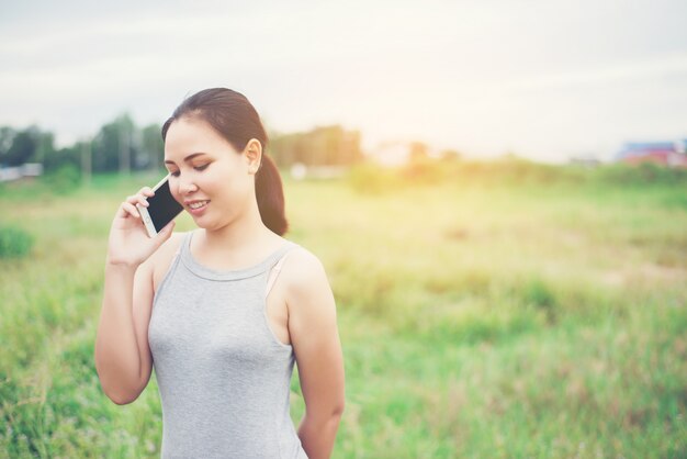 Mujer hablando por teléfono en el campo