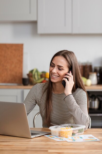 Mujer hablando por teléfono y esperando para comer