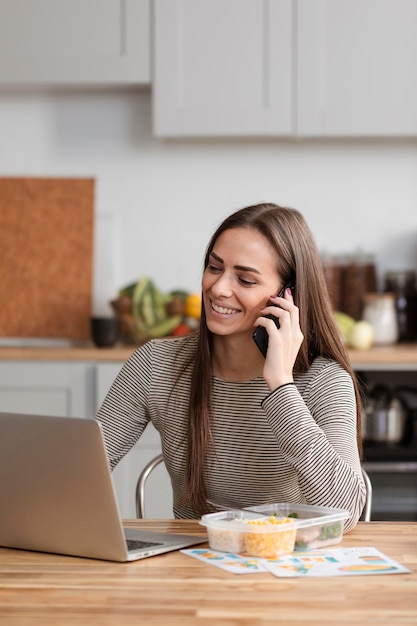 Mujer hablando por teléfono y esperando para comer