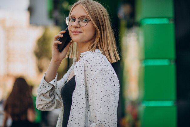 Mujer hablando por teléfono fuera de la calle