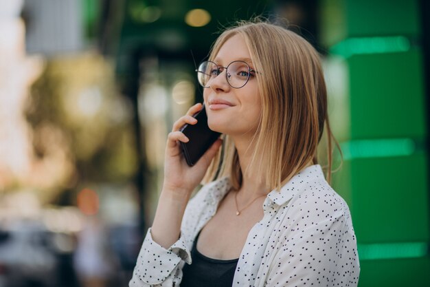 Mujer hablando por teléfono fuera de la calle