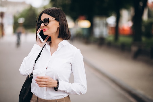 Foto gratuita mujer hablando por teléfono fuera de las calles de la ciudad