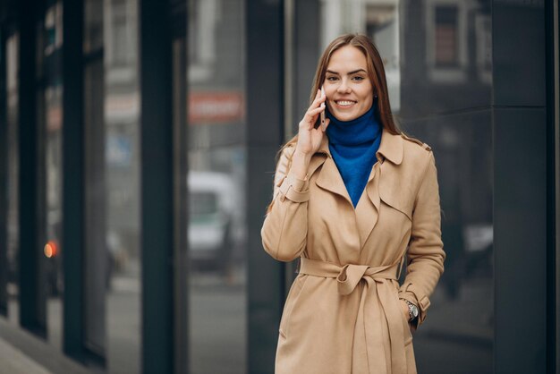 Mujer hablando por teléfono junto al banco