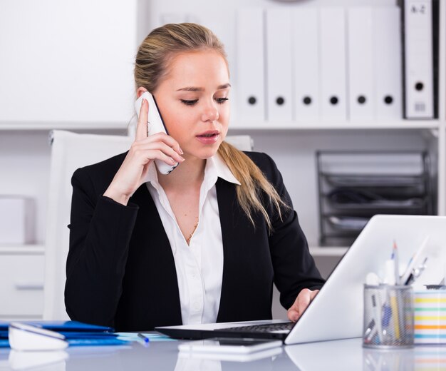 Mujer hablando por teléfono en la oficina